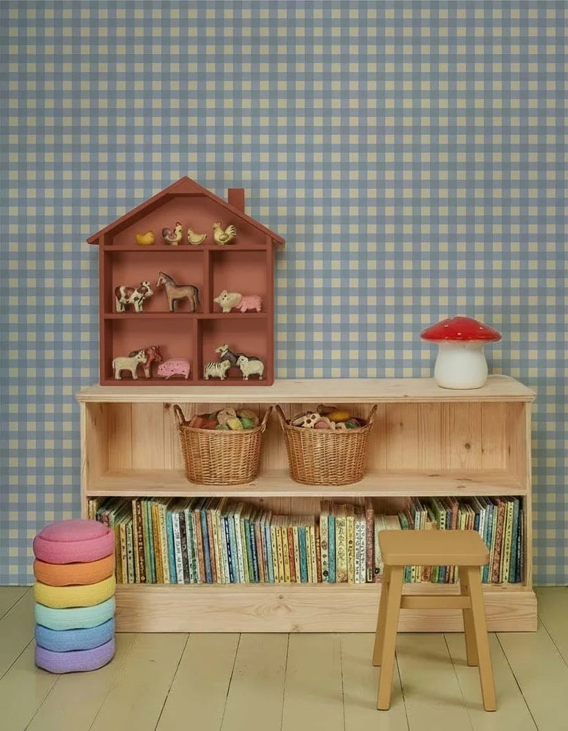Gingham Ruiten Lichtblauw – Atelier Chien : papier peint derrière une armoire en bois avec des livres et des jouets.