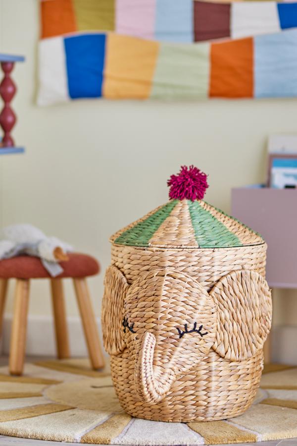 Bobo Basket Nature – Elefanten-Aufbewahrungskorb mit Deckel – Bloomingville MINI: Korb mit Elefantengesicht neben einem Kinderbett.