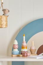 Celebrate Activity Toy – Bloomingville MINI : jouet à empiler sur une étagère dans la chambre d'enfant.
