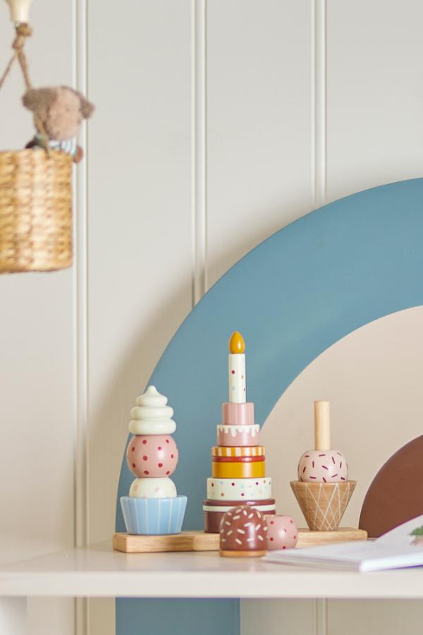 Celebrate Activity Toy – Bloomingville MINI : jouet à empiler sur une étagère dans la chambre d'enfant.
