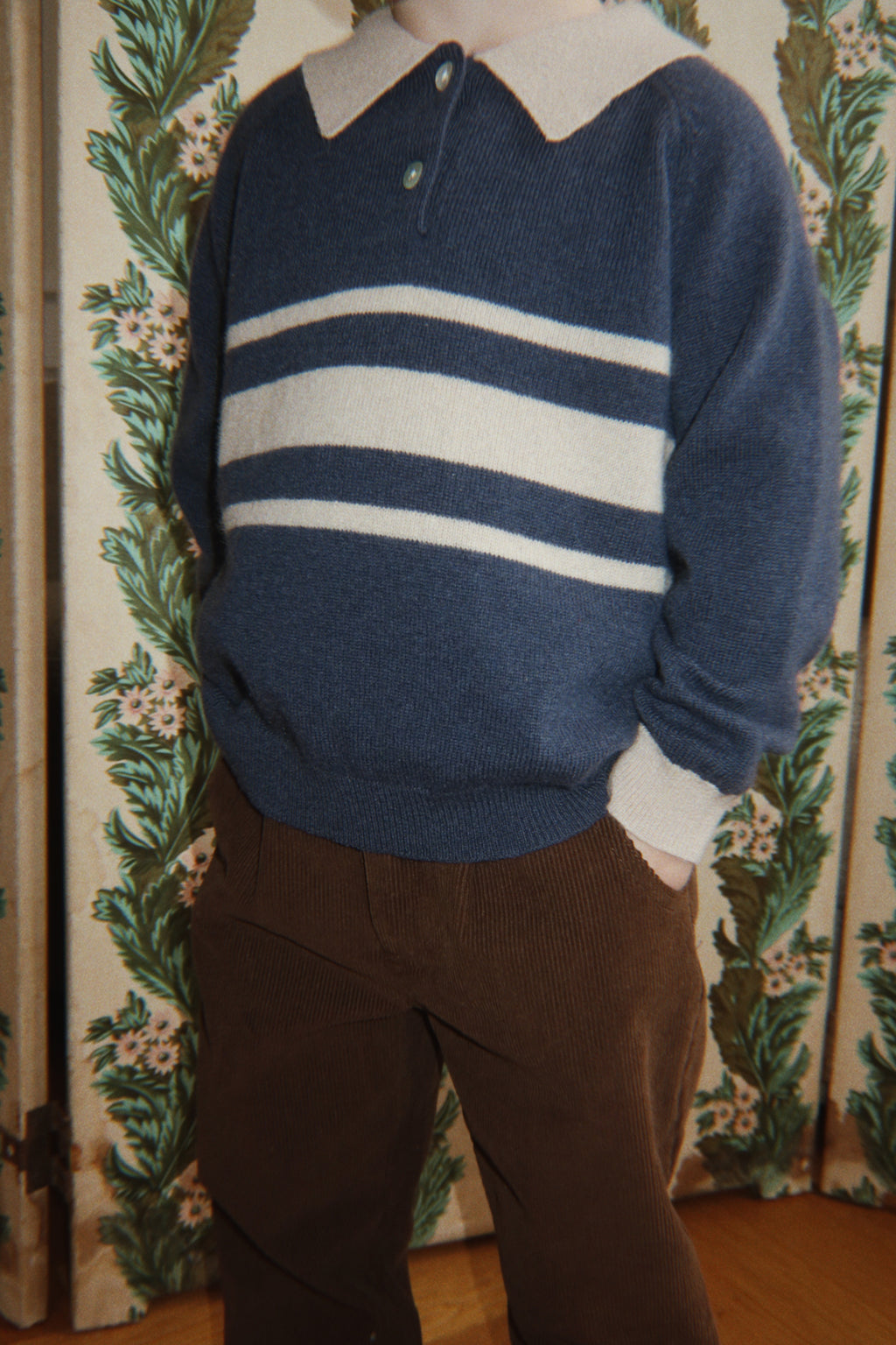 Polo en laine Basi – Dark Blue Stripe – Konges Sløjd : détail du polo bleu foncé à rayures claires porté.