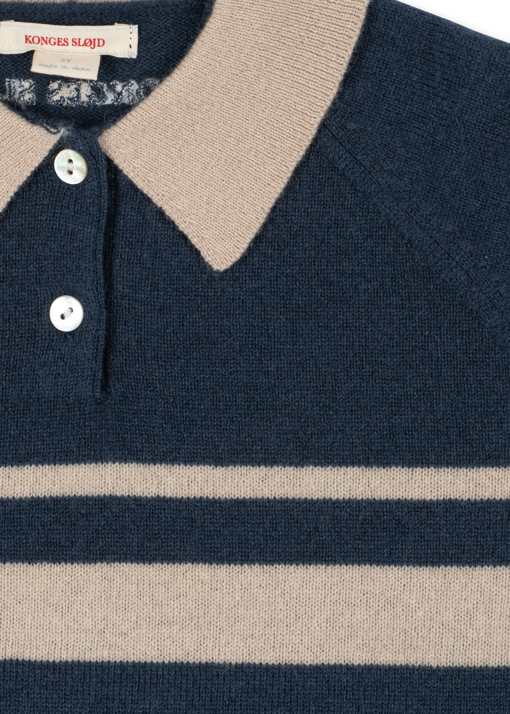 Polo en laine Basi – Dark Blue Stripe – Konges Sløjd : détail du col clair, des boutons et des rayures du polo bleu.