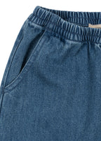 Denimhose Magot – Denim Blue – Konges Sløjd: Detail des elastischen Bunds und der Eingrifftasche der Denimhose.