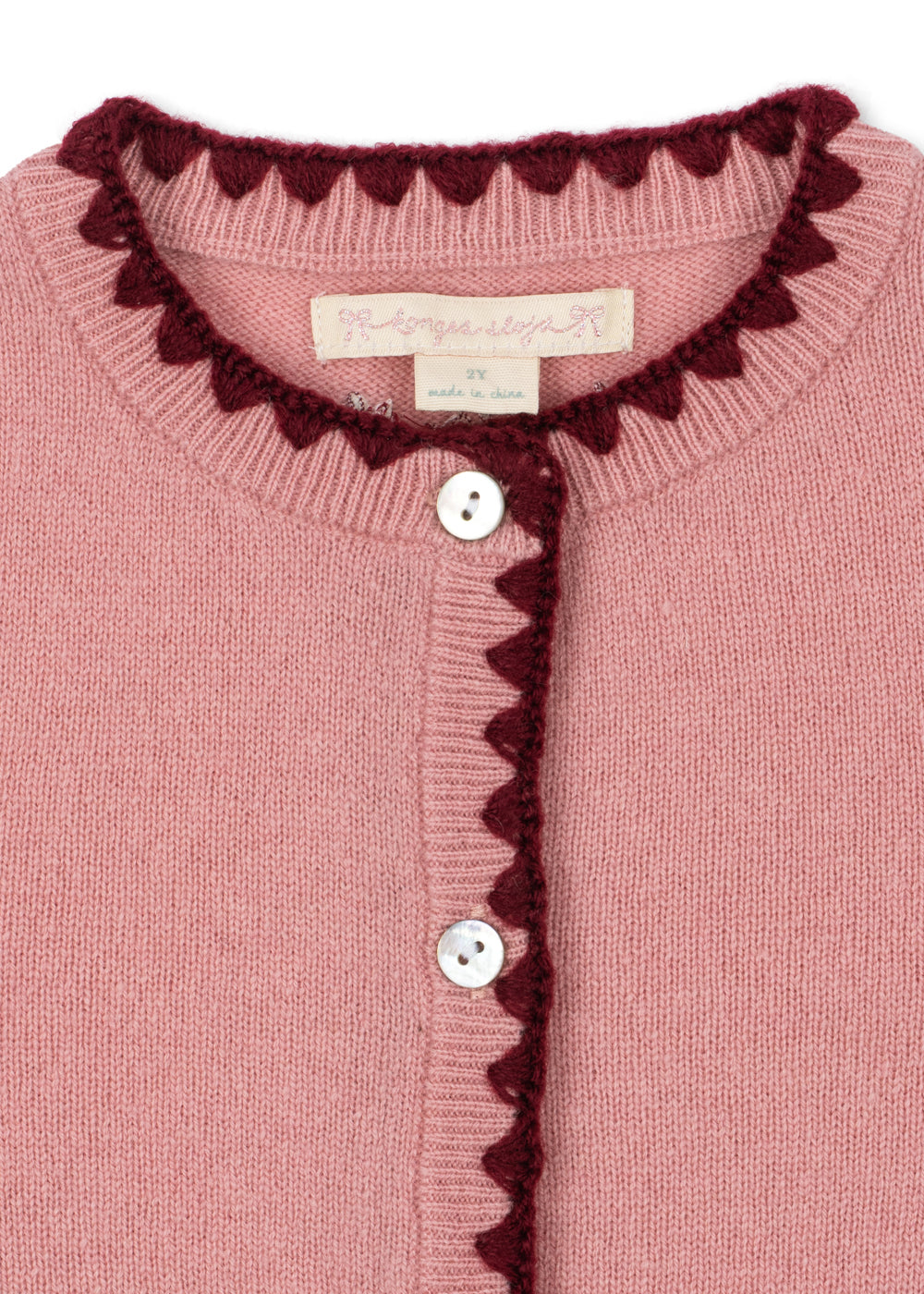 Wollen vest Collette – Pale Blush – Konges Sløjd: detail van de hals en knoopsluiting met donkere rand.