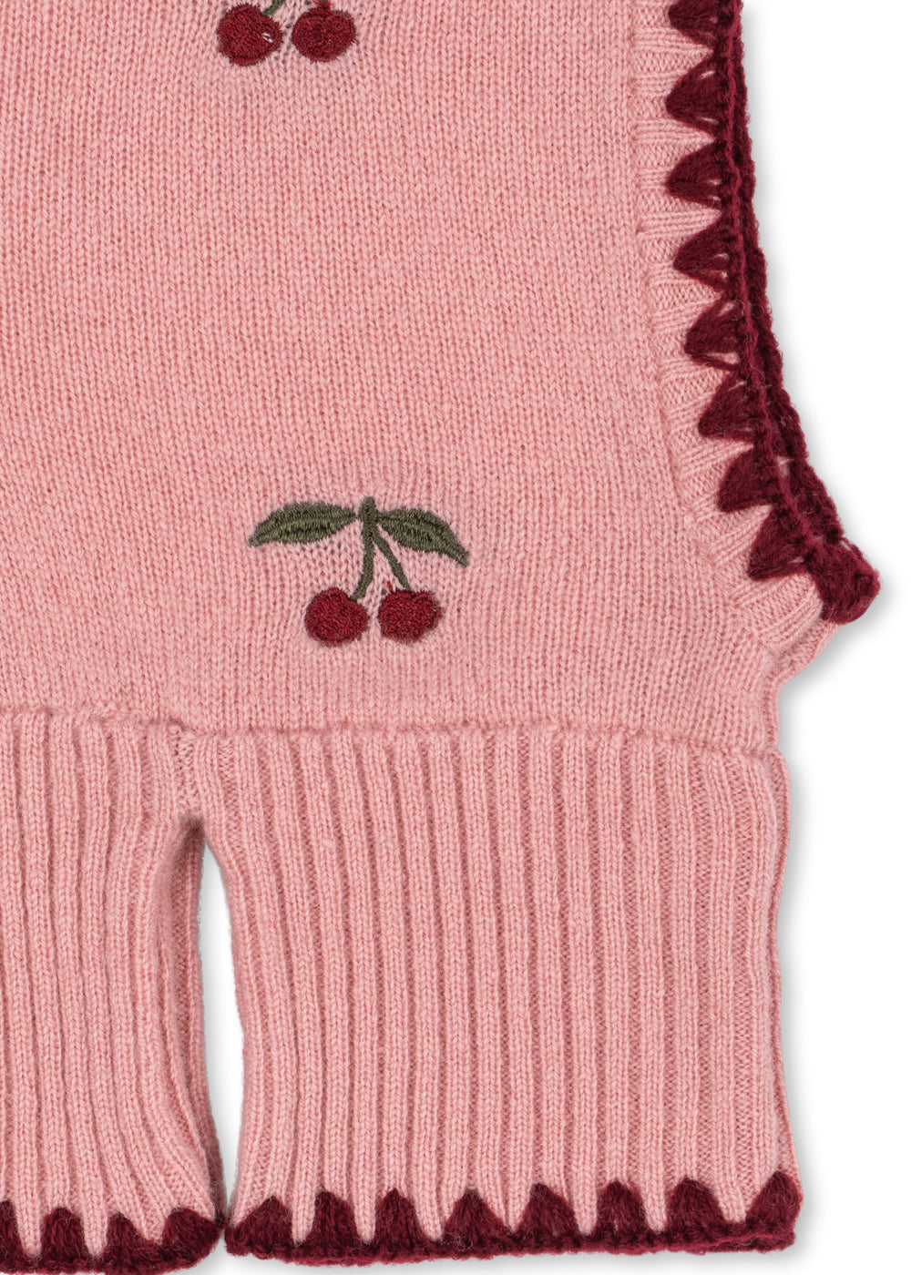 Cagoule en laine Collette – Pale Blush – Konges Sløjd : détail des cerises, du liseré sombre et de la bordure côtelée de la cagoule.